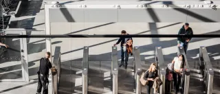 People are going though automatic gates checking their passports and tickets at the Länsisatama ferry terminal in Helsinki
